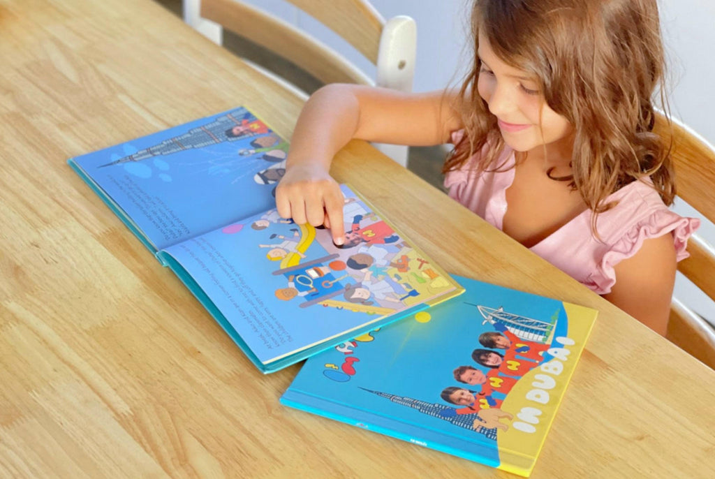 A girl pointing to a image in personalized book with smile 